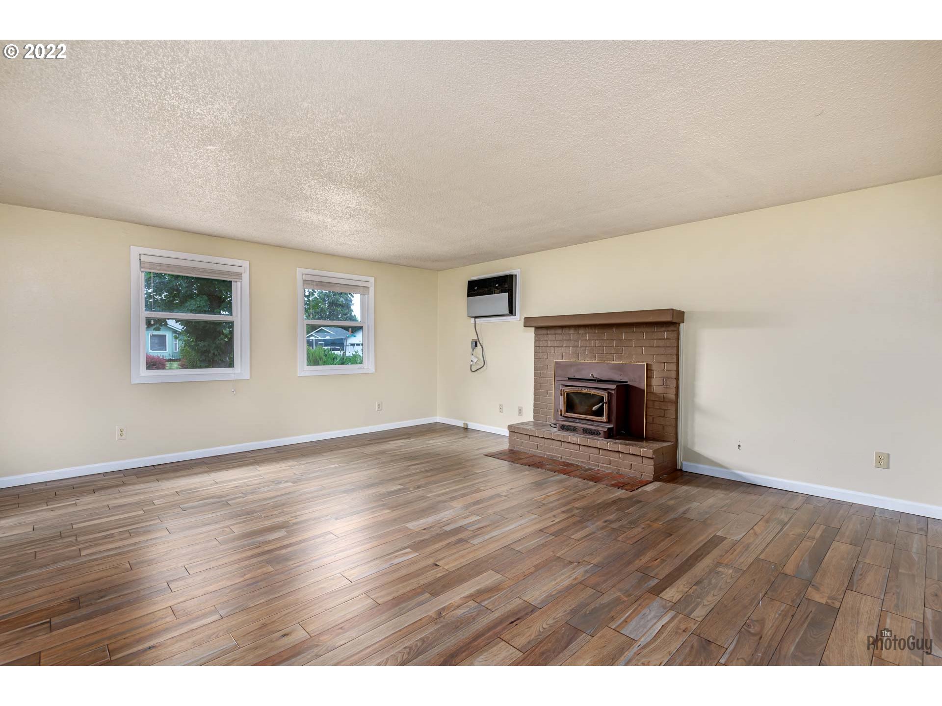 529 Sandstone Way Eugene, OR 97402 - Photo 6 of 19 a view of empty room with wooden floor and fireplace