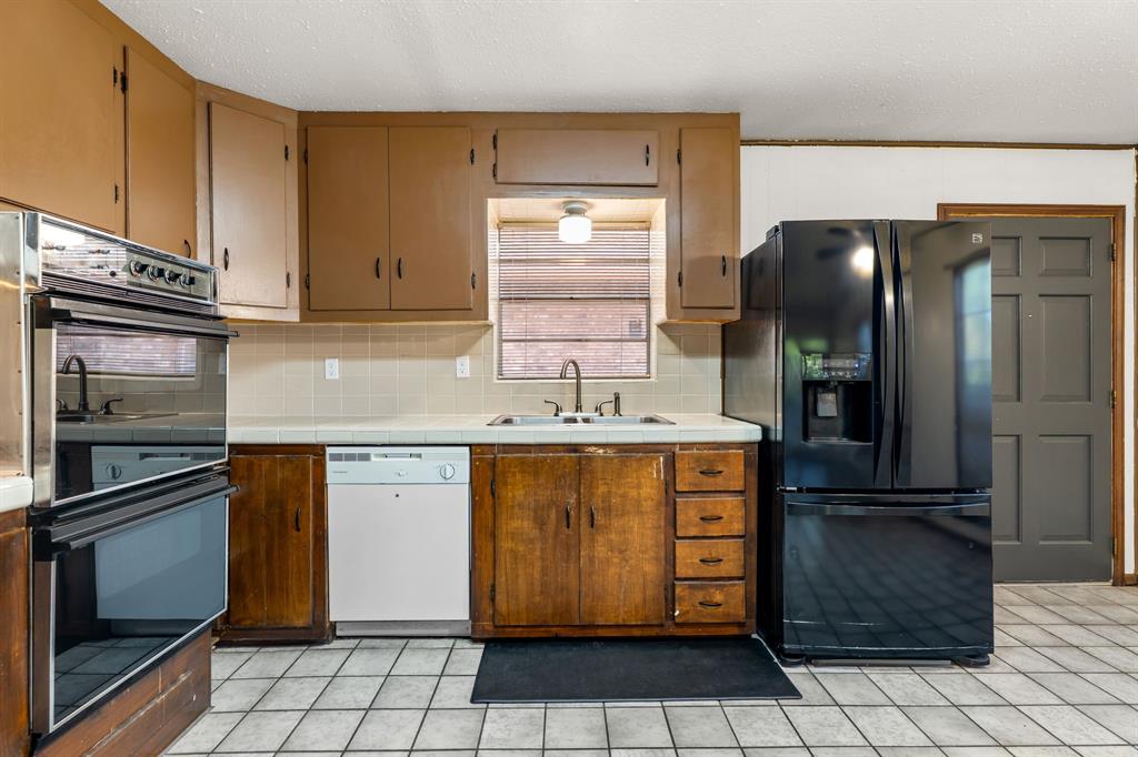373 Ingred Street Waco, TX 76705 - Photo 12 of 39 a kitchen with a refrigerator and cabinets