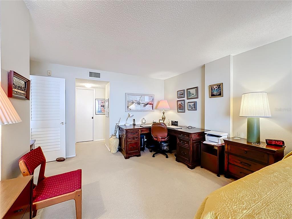 6415 Midnight Pass Road, Unit 705 Sarasota, FL 34242 - Photo 17 of 44 a bed room with furniture and a lamp