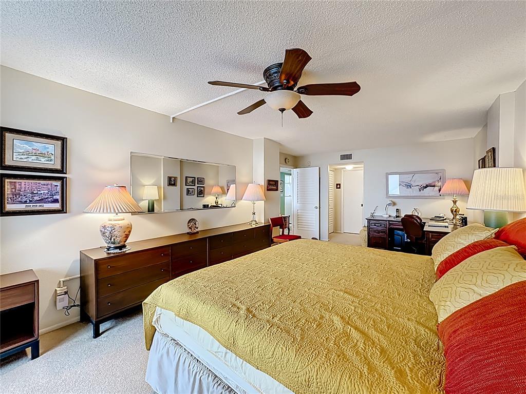 6415 Midnight Pass Road, Unit 705 Sarasota, FL 34242 - Photo 18 of 44 a bed room with a bed and a ceiling fan