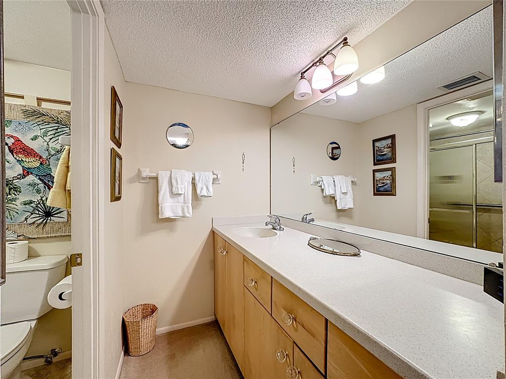 6415 Midnight Pass Road, Unit 705 Sarasota, FL 34242 - Photo 19 of 44 a spacious bathroom with a sink a large mirror and a shower