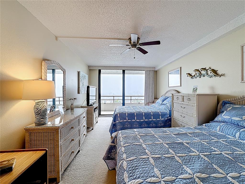6415 Midnight Pass Road, Unit 705 Sarasota, FL 34242 - Photo 22 of 44 a bedroom with a large bed and a chandelier