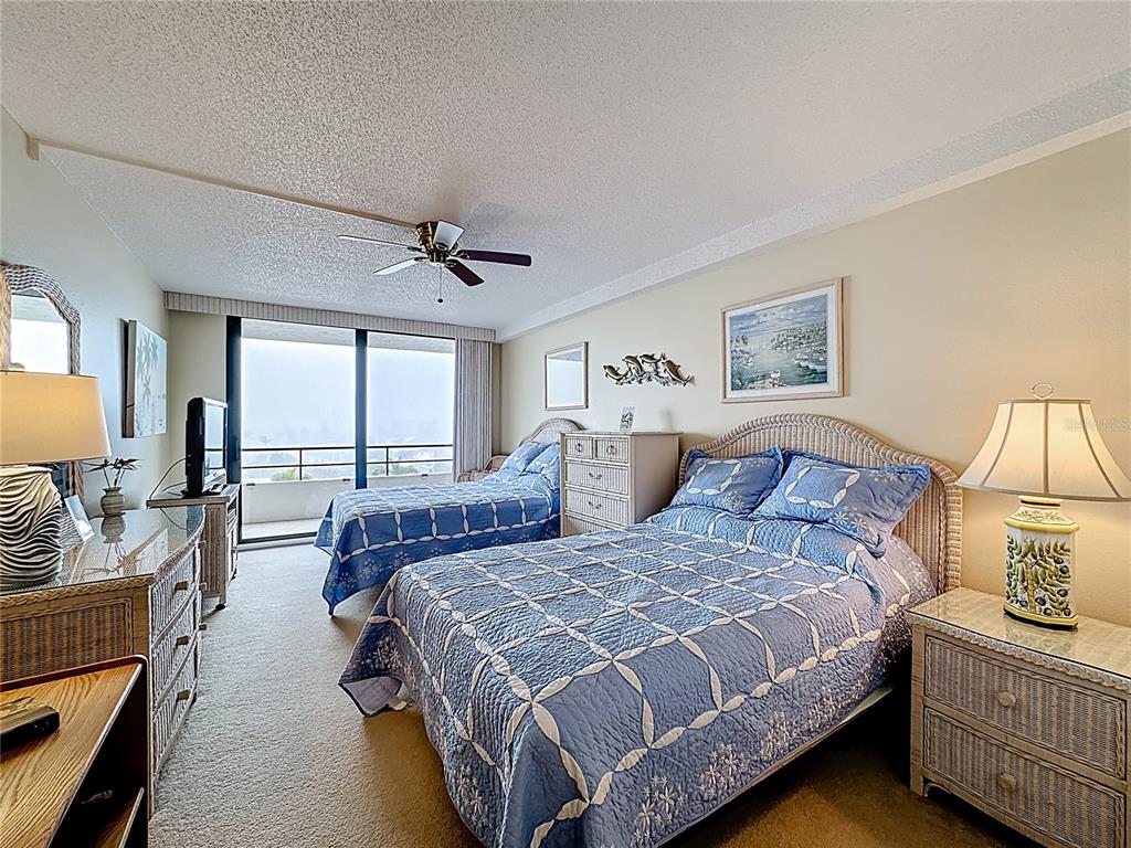 6415 Midnight Pass Road, Unit 705 Sarasota, FL 34242 - Photo 23 of 44 a spacious bedroom with a bed a couch and a large window