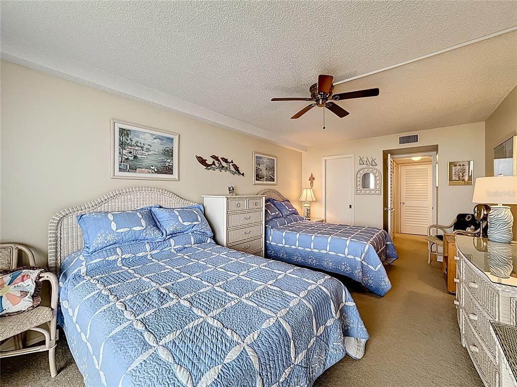 6415 Midnight Pass Road, Unit 705 Sarasota, FL 34242 - Photo 24 of 44 a bedroom with two beds and a chandelier