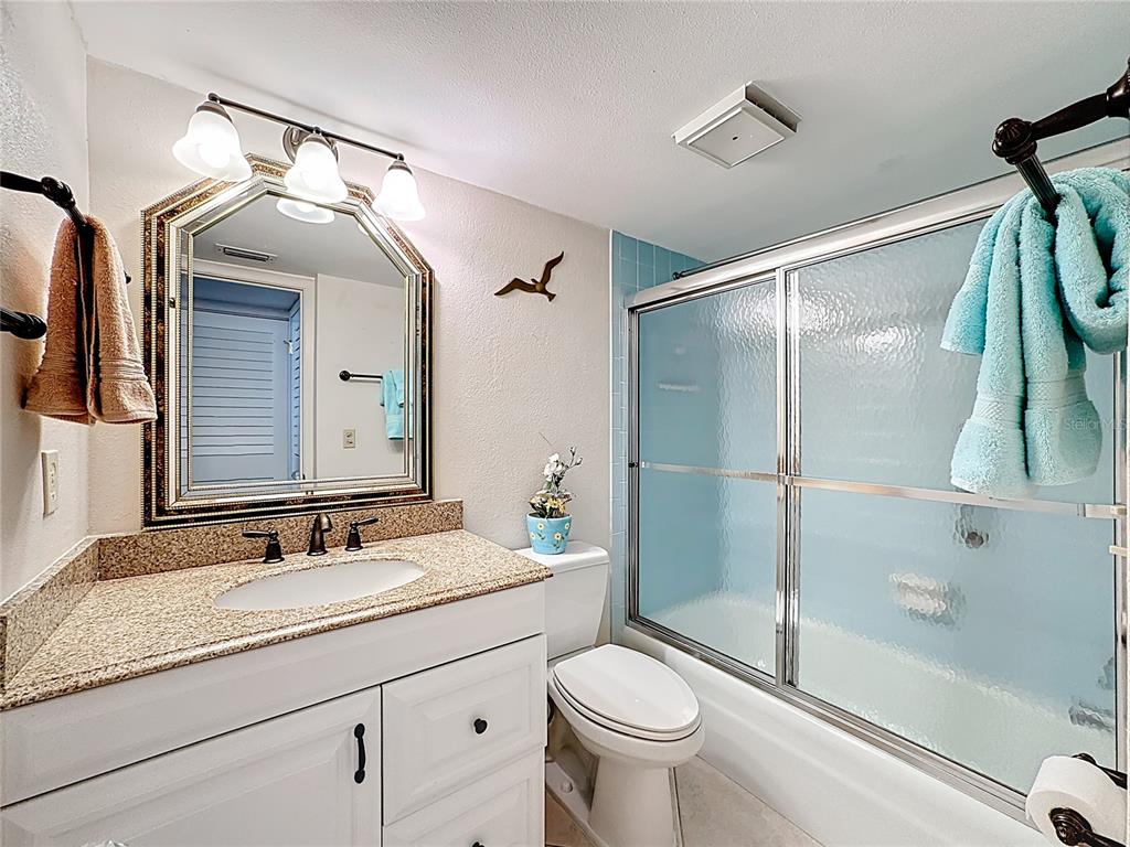 6415 Midnight Pass Road, Unit 705 Sarasota, FL 34242 - Photo 25 of 44 a bathroom with a granite countertop sink mirror vanity and toilet