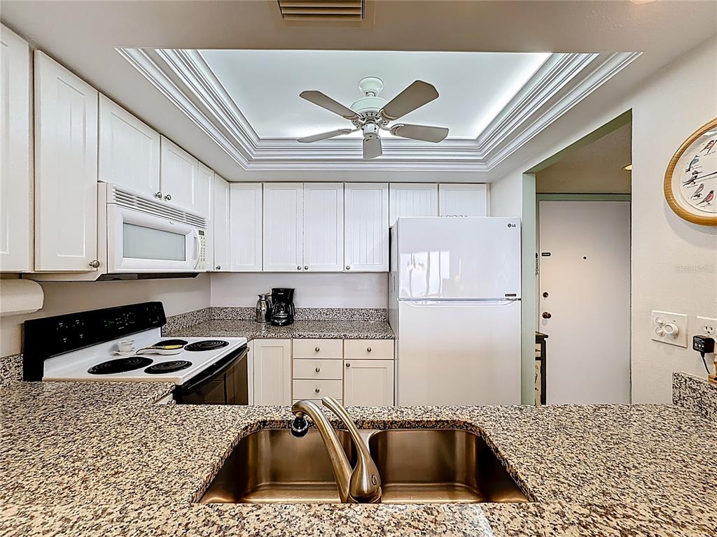 6415 Midnight Pass Road, Unit 705 Sarasota, FL 34242 - Photo 7 of 44 a kitchen with a refrigerator and a sink