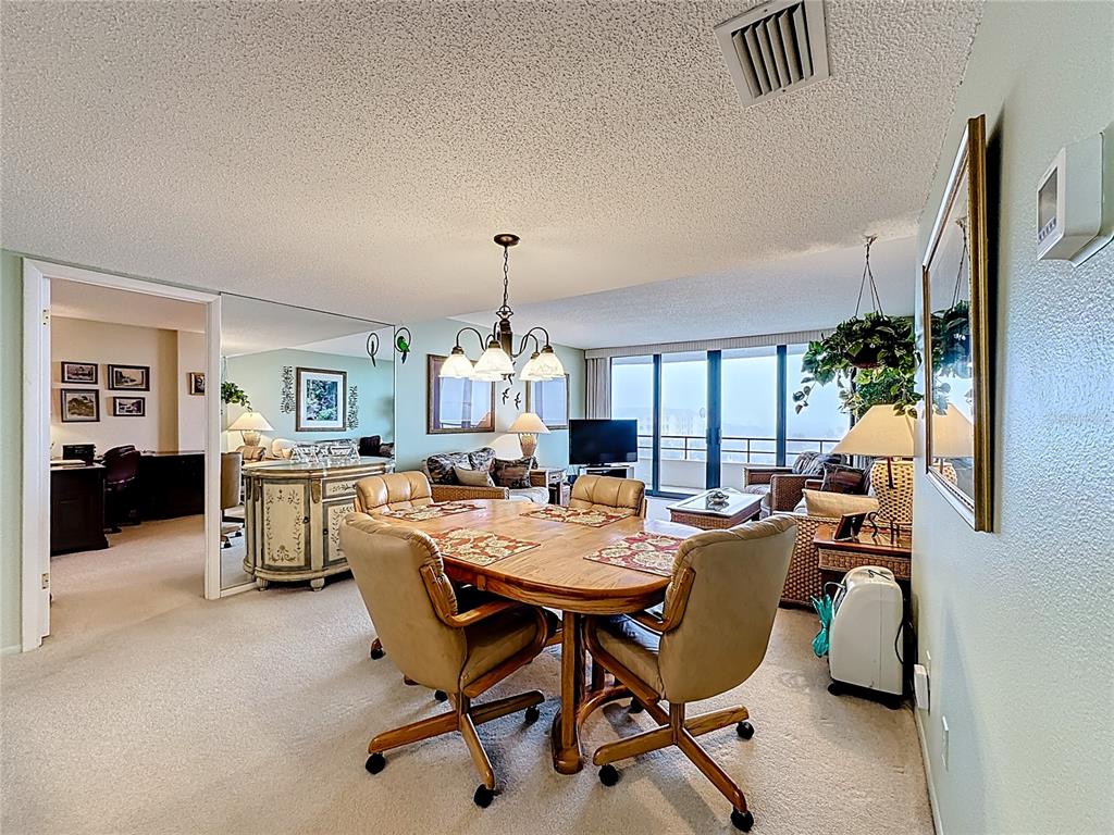 6415 Midnight Pass Road, Unit 705 Sarasota, FL 34242 - Photo 9 of 44 a view of a dining room with furniture and a livingroom