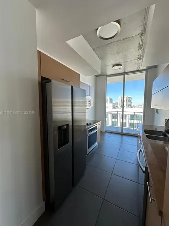 a kitchen with granite countertop a refrigerator and stove