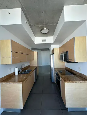 a kitchen with stainless steel appliances granite countertop a sink and a stove