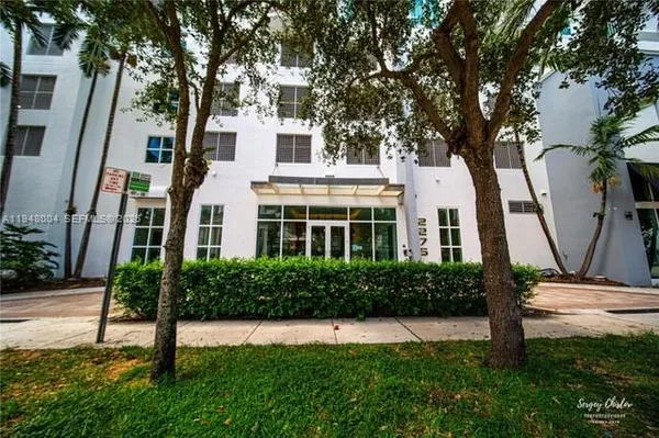 a view of a white house next to a yard