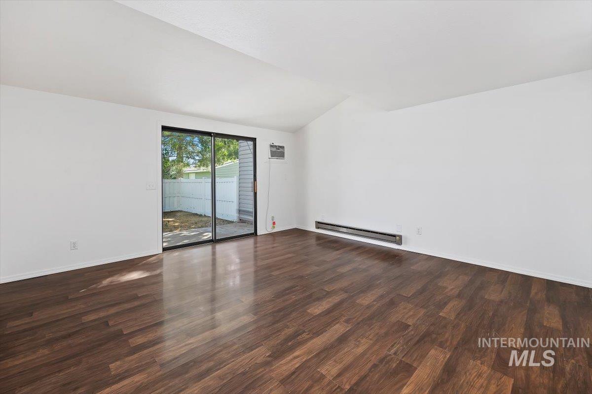 259 Pheasant Road, Unit 84 Twin Falls, ID 83301 - Photo 7 of 25 Spacious room featuring wood-finish flooring, white walls, and a vaulted ceiling