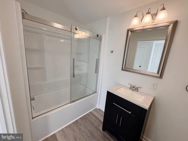 a bathroom with a sink vanity mirror and shower