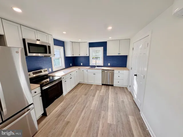 a kitchen with a sink a microwave and cabinets