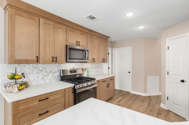 a kitchen with stainless steel appliances a stove microwave and sink