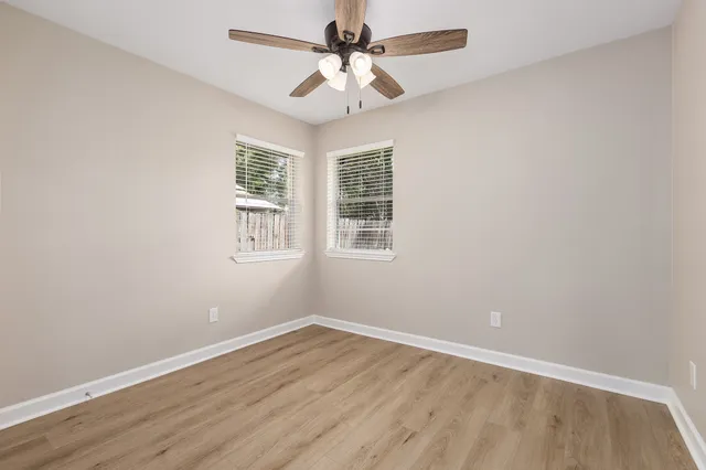 a view of a room with wooden floor and windows
