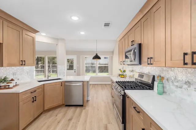a kitchen with granite countertop a sink stove and cabinets