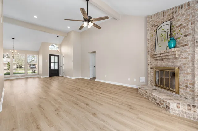 a view of a livingroom with a fireplace a chandelier and wooden floor
