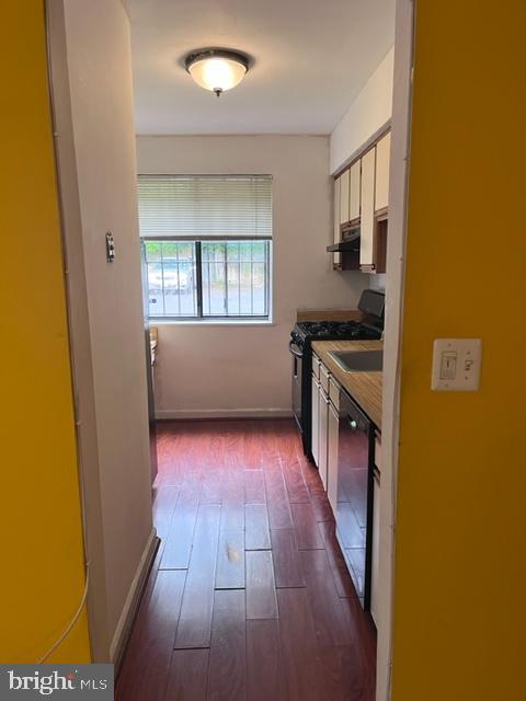 4721 1st Street Southwest, Unit 101 Washington, DC 20032 - Photo 3 of 15 a kitchen with a wooden floor and a stove