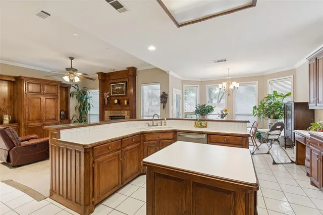 a kitchen with a stove a sink a counter top space and living room view