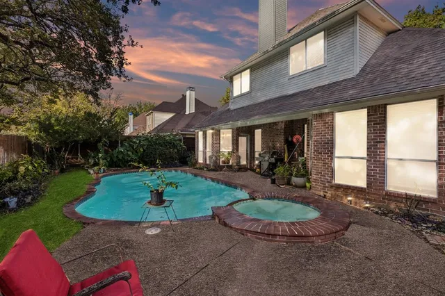 a view of a backyard with table and chairs potted plants and wooden fence