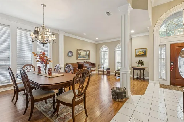a dining room with furniture a chandelier and wooden floor