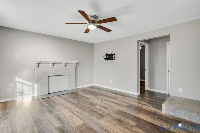 a view of a livingroom with wooden floor and a ceiling fan