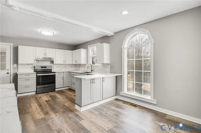 a kitchen with white cabinets and appliances
