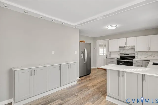 a kitchen with white cabinets and stainless steel appliances