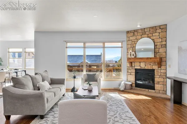 a living room with furniture a fireplace and a floor to ceiling window
