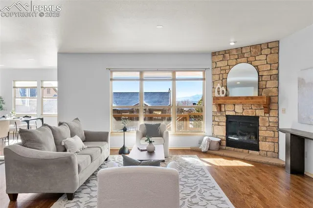 a living room with furniture a fireplace and a floor to ceiling window