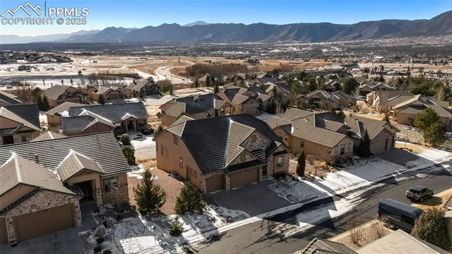 an aerial view of residential houses with outdoor space and trees