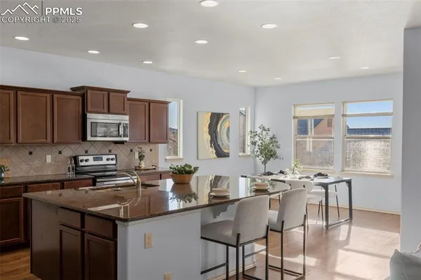 a kitchen with stainless steel appliances granite countertop a sink and cabinets
