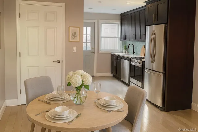 a kitchen with stainless steel appliances granite countertop a dining table and chairs