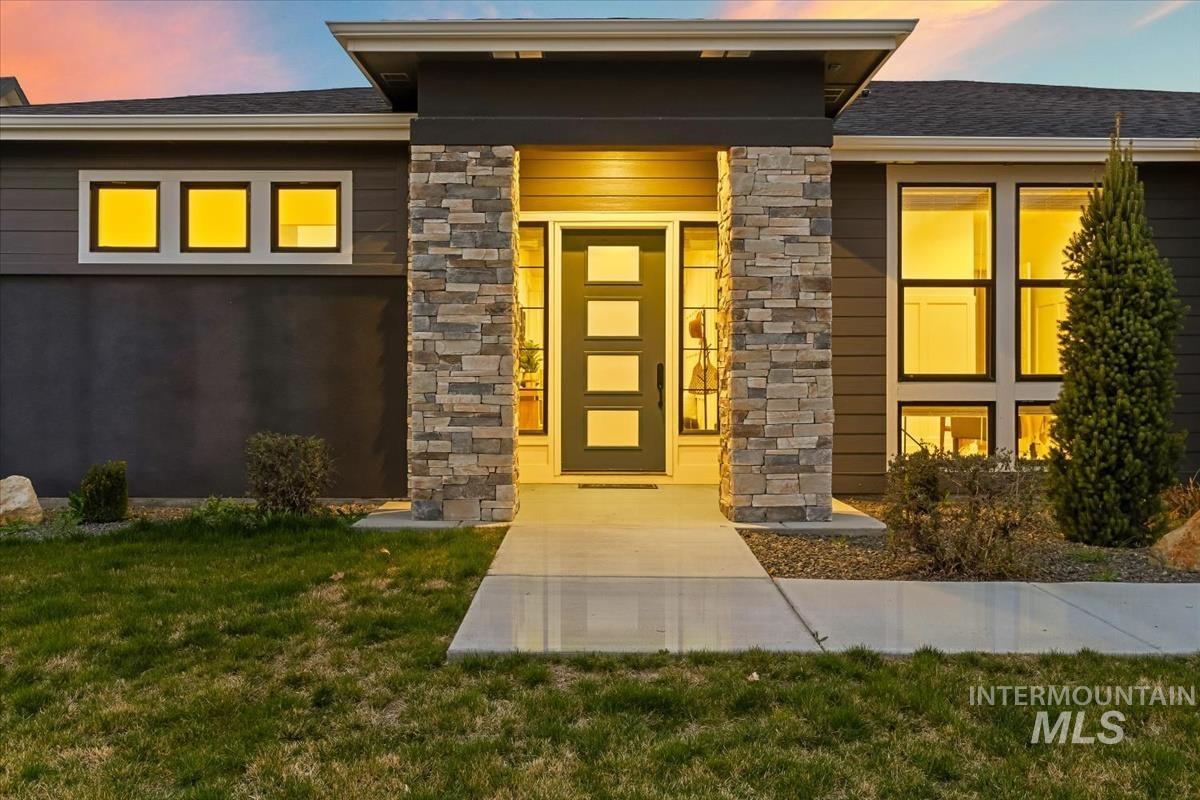 3882 West Haverhill Street Eagle, ID 83616 - Photo 2 of 41 Doorway to property featuring stone siding, a lawn, and a shingled roof