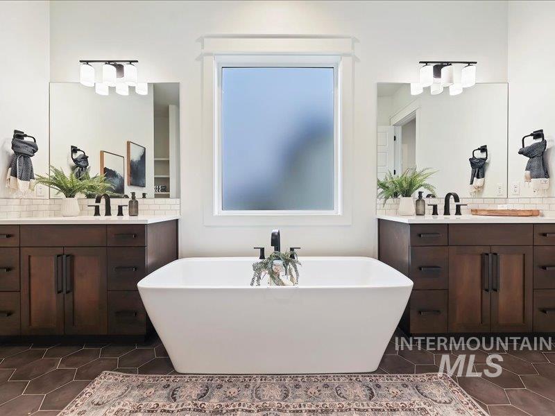 3882 West Haverhill Street Eagle, ID 83616 - Photo 23 of 41 Bathroom featuring two vanities, a soaking tub, tasteful backsplash, and dark tile patterned flooring