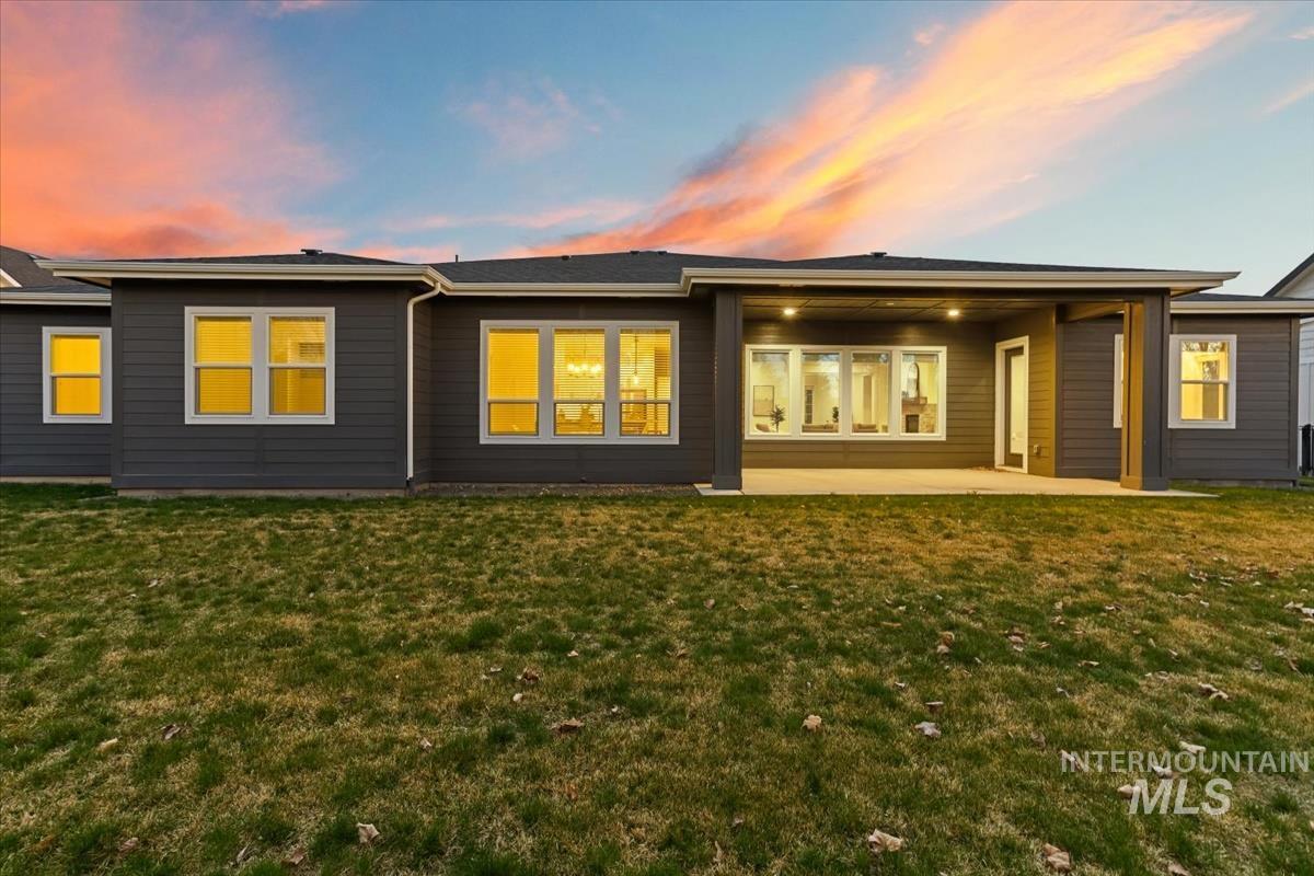 3882 West Haverhill Street Eagle, ID 83616 - Photo 36 of 41 Back of property at dusk with a patio and a lawn