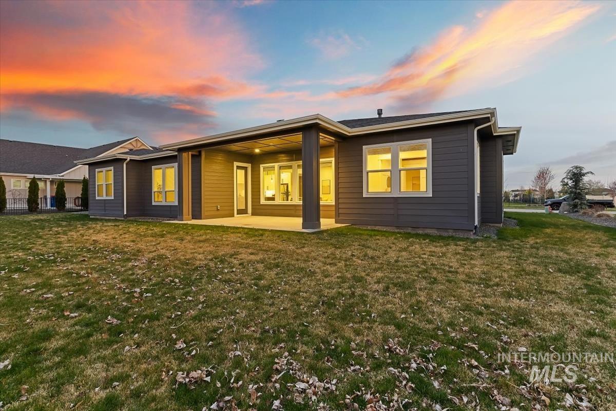 3882 West Haverhill Street Eagle, ID 83616 - Photo 37 of 41 Back of house at dusk featuring a patio area and a yard