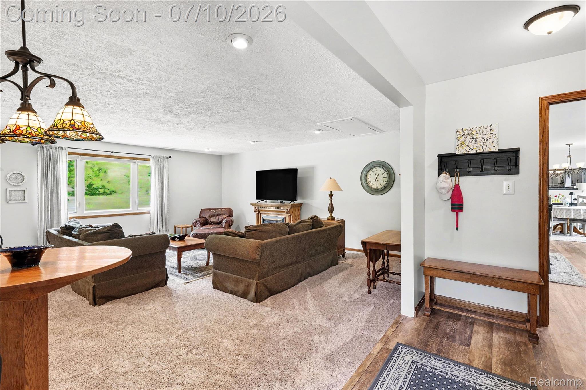 2180 Hurst Road St. Clair, MI 48079 - Photo 9 of 39 Carpeted living area featuring a large picture window, recessed lighting, and a decorative stained-glass chandelier
