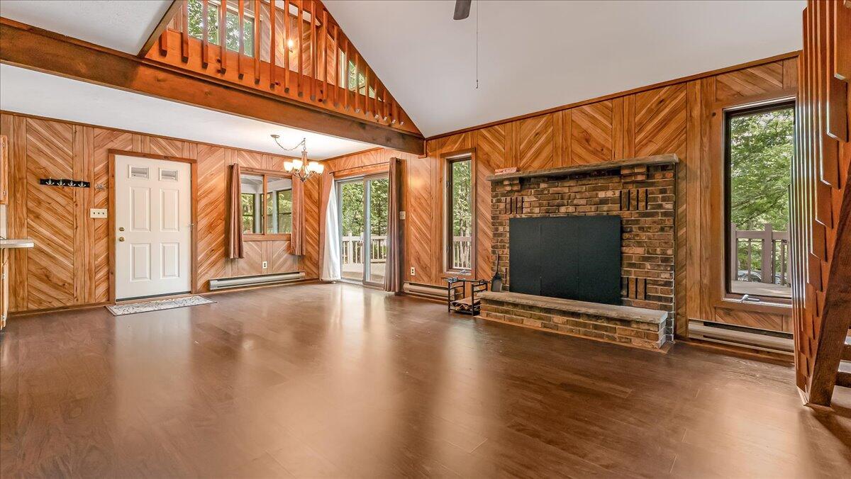 5913 Decker Road Bushkill, PA 18324 - Photo 9 of 53 an empty room with wooden floor fireplace and windows