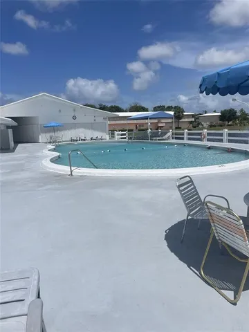 a view of a swimming pool with outdoor seating and plants