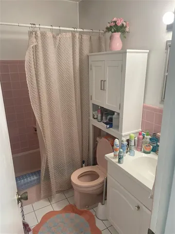a bathroom with a sink a toilet a mirror and shower curtain