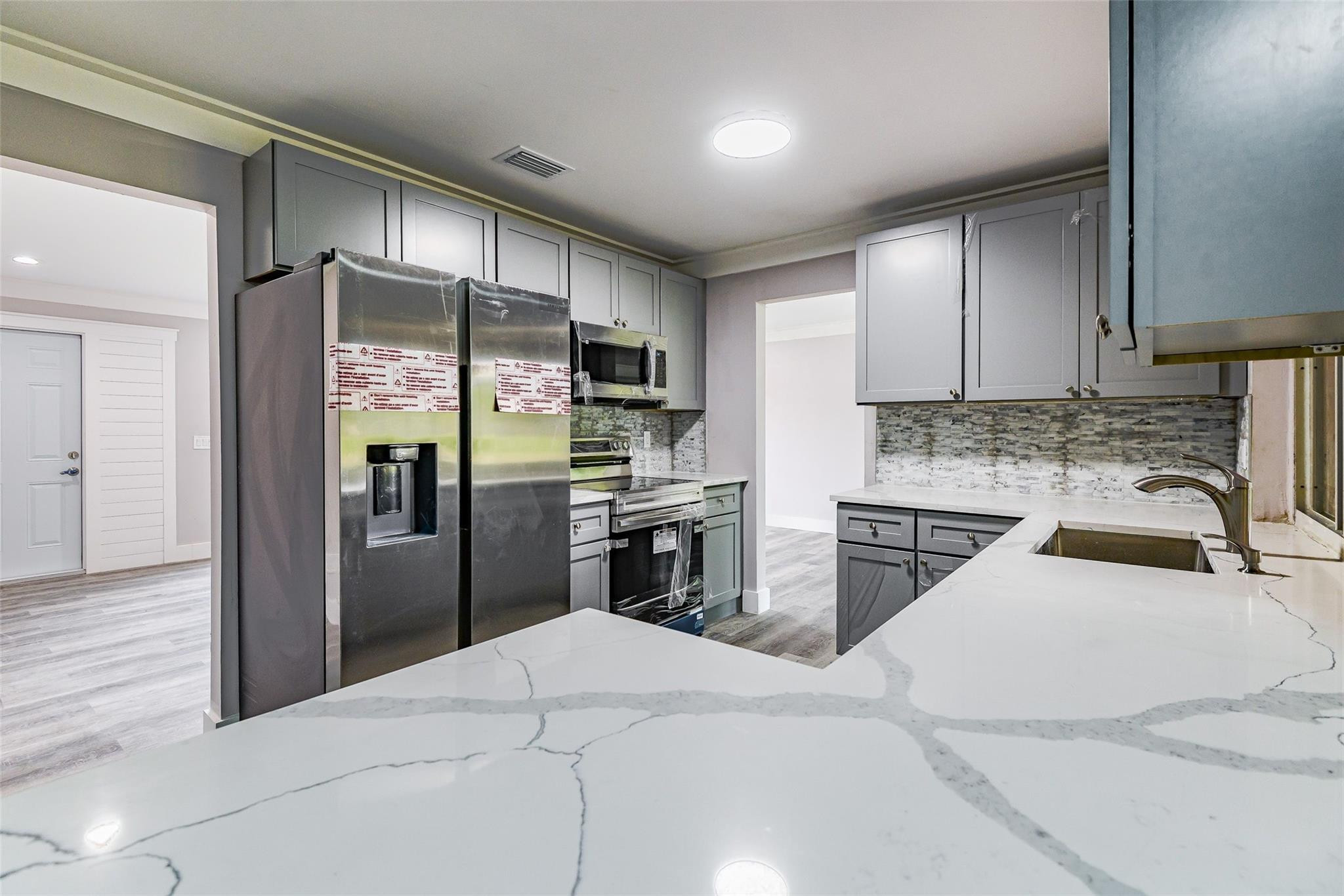 22500 Labrador Street Boca Raton, FL 33428 - Photo 14 of 30 a kitchen with stainless steel appliances kitchen island granite countertop a refrigerator sink and cabinets
