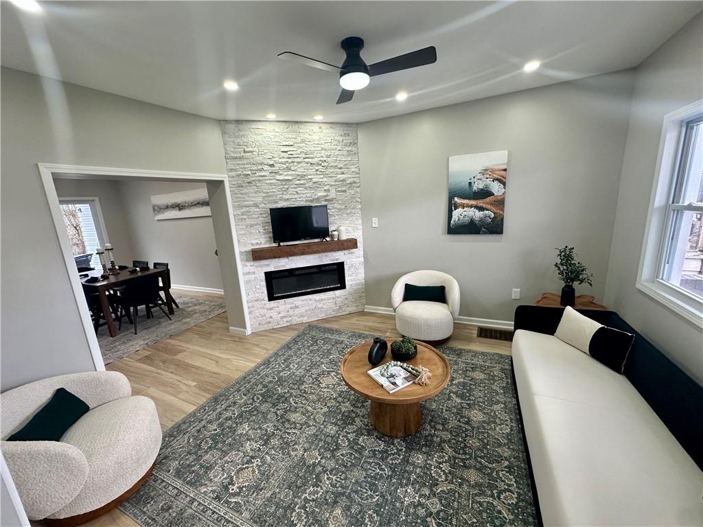 411 Kambach Street Pittsburgh, PA 15211 - Photo 12 of 47 Spacious Living Room features high ceilings, recessed lighting, excellent natural light, stone (electric) fireplace, remote ceiling fan, and luxury plank vinyl flooring (throughout the home)!