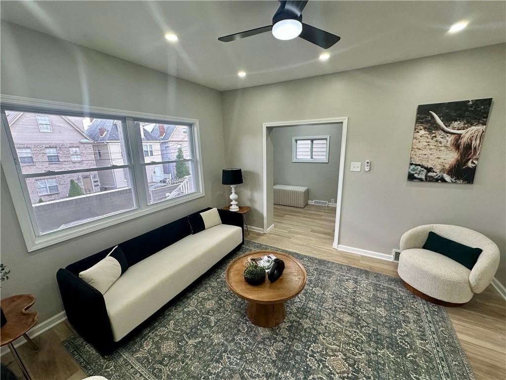 411 Kambach Street Pittsburgh, PA 15211 - Photo 13 of 47 Spacious Living Room features high ceilings, recessed lighting, excellent natural light, stone (electric) fireplace, remote ceiling fan, and luxury plank vinyl flooring (throughout the home)!