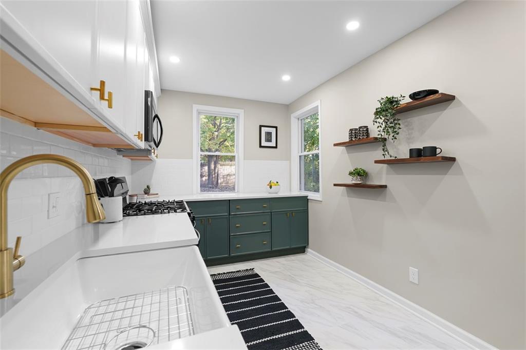 411 Kambach Street Pittsburgh, PA 15211 - Photo 17 of 47 Large Galley style Kitchen is a stunner featuring shaker cabinets galore, quartz countertops, large farm style sink, excellent natural light, ceramic tile flooring, and stainless steel appliances!