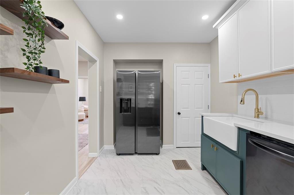 411 Kambach Street Pittsburgh, PA 15211 - Photo 18 of 47 Large Galley style Kitchen is a stunner featuring shaker cabinets galore, quartz countertops, large farm style sink, excellent natural light, ceramic tile flooring, and stainless steel appliances!