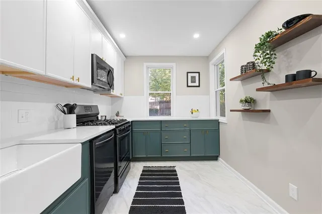 a kitchen with stainless steel appliances a stove a microwave and sink