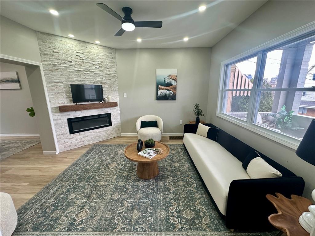 411 Kambach Street Pittsburgh, PA 15211 - Photo 10 of 47 Spacious Living Room features high ceilings, recessed lighting, excellent natural light, stone (electric) fireplace, remote ceiling fan, and luxury plank vinyl flooring (throughout the home)!