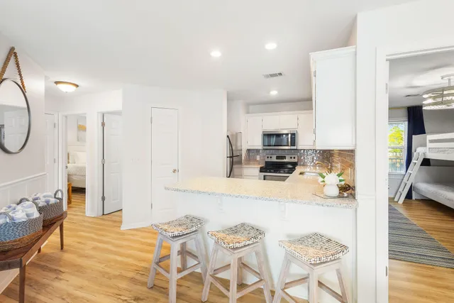 a large kitchen with stainless steel appliances kitchen island granite countertop a refrigerator and a stove top oven