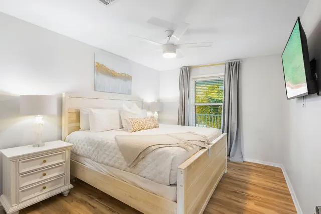 a bedroom with a bed and a flat tv screen on dresser